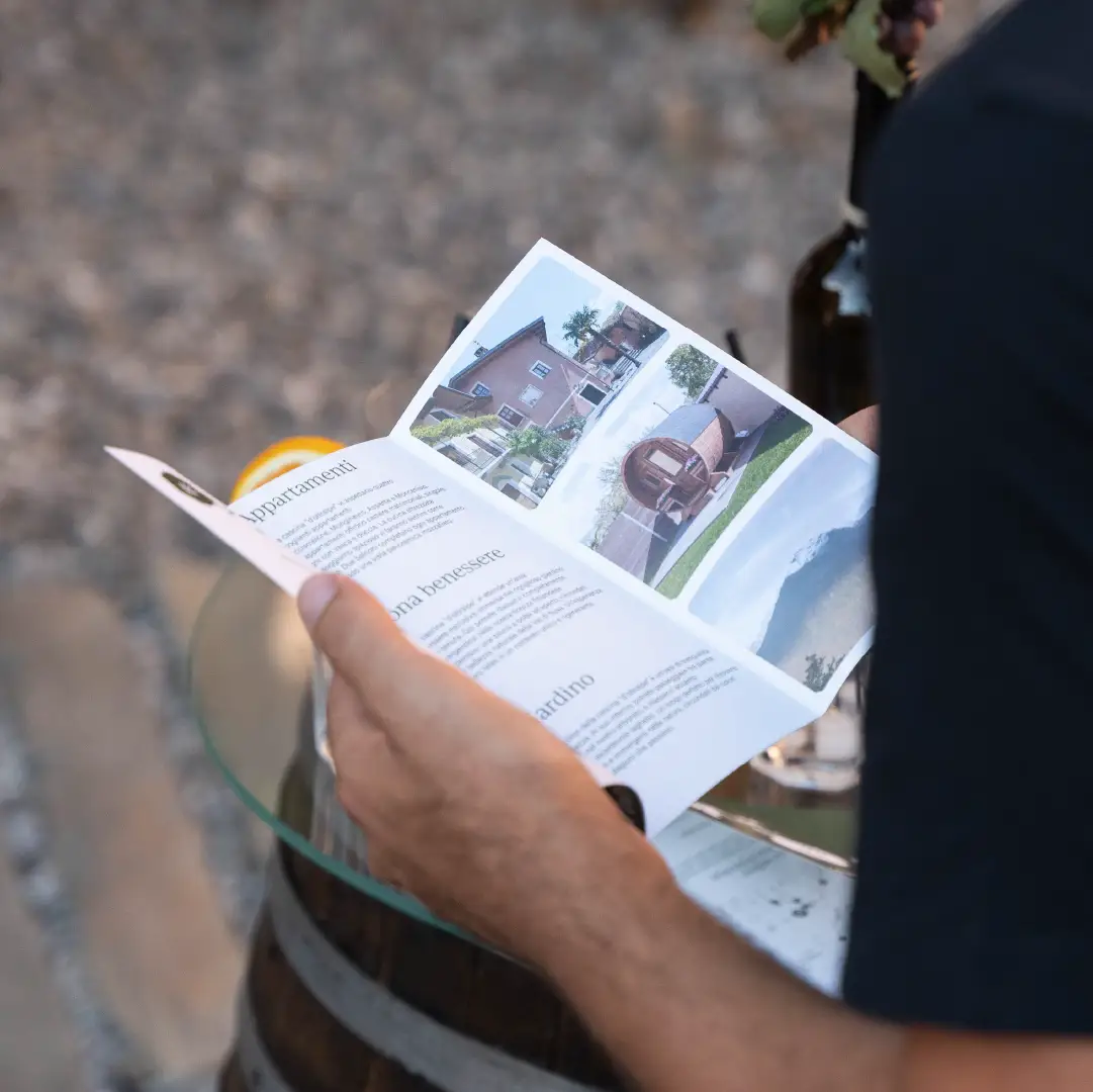 Un ragazzo tiene in mano il pieghevole della cascina d'Oltralpe